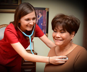 caregiver talking elderly woman's heart rate